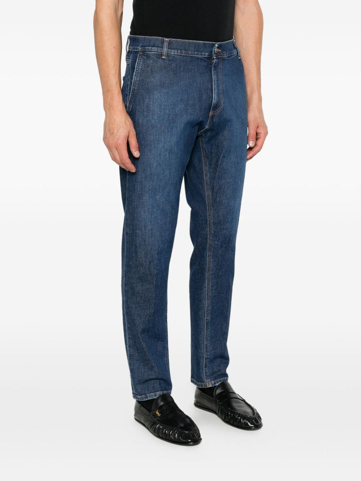 Jeans con impunture a contrasto e logo blu 