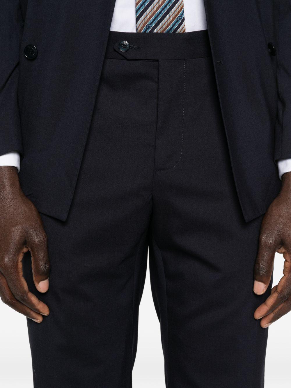 Abito blu navy doppiopetto con spilla sul revers 