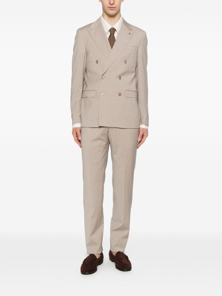 Abito beige doppiopetto con spilla sul revers 