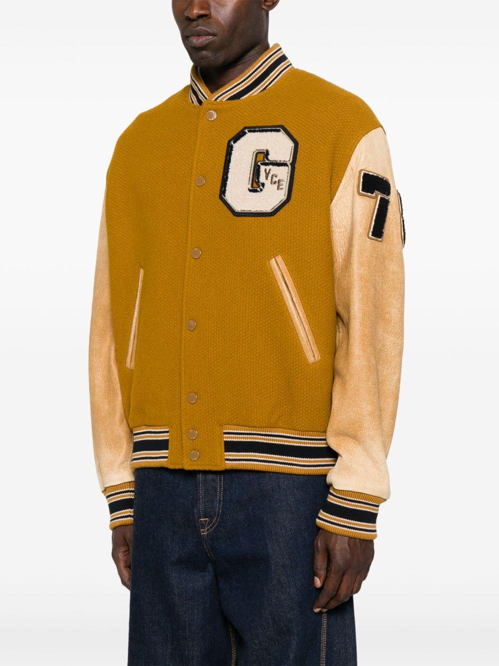 Giacca giallo mostarda con maniche in pelle e applicazione varsity 