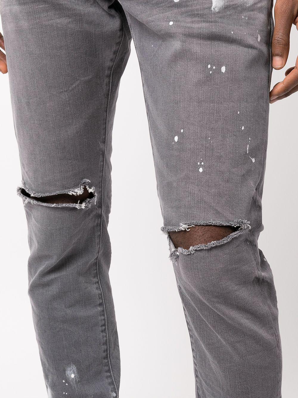 Jeans slim con effetto vissuto e dettaglio vernice 