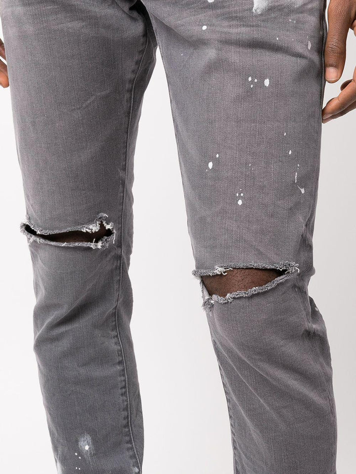 Jeans slim con effetto vissuto e dettaglio vernice 