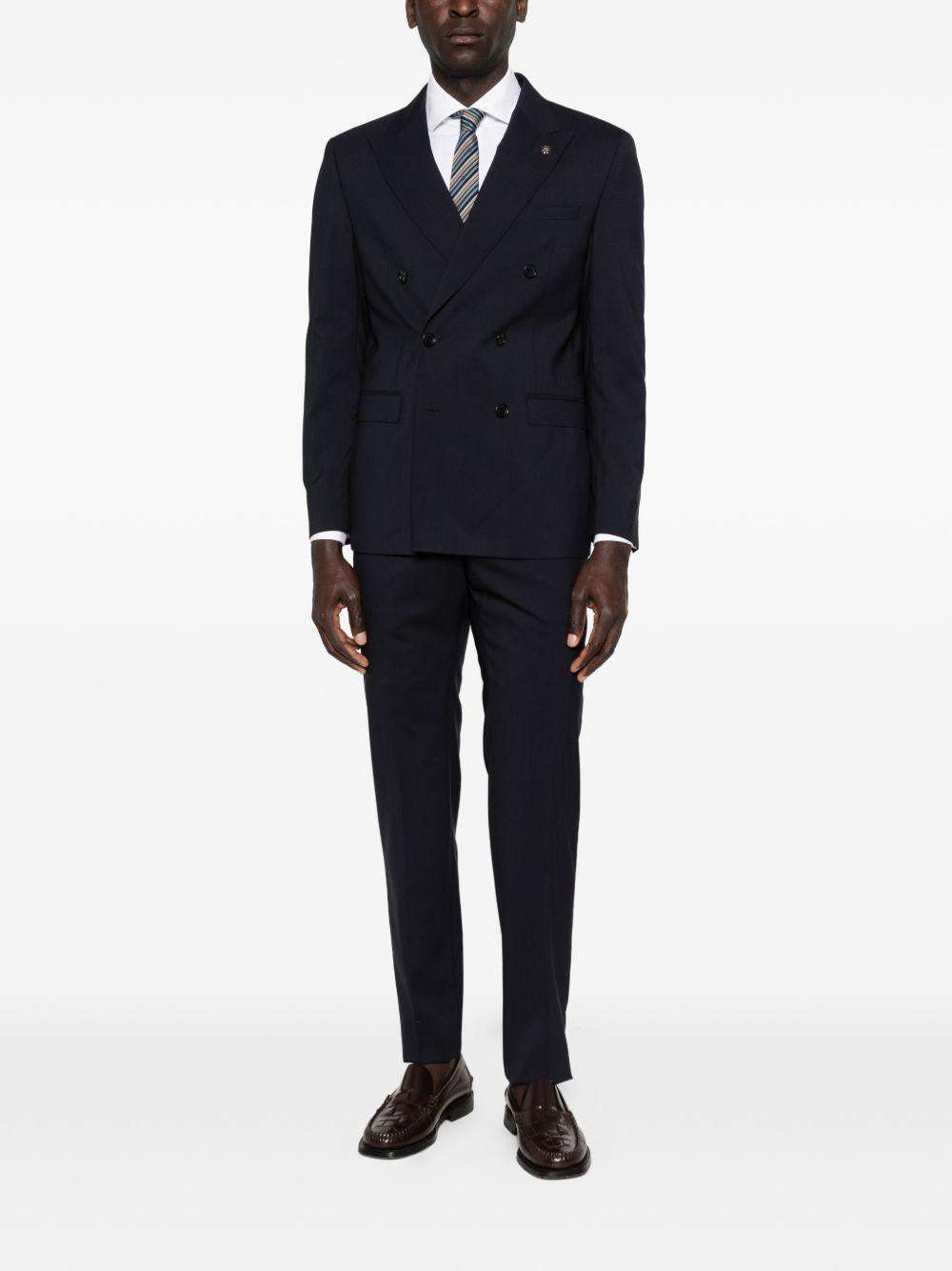 Abito blu navy doppiopetto con spilla sul revers 