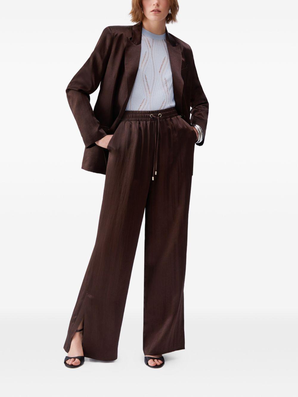 Pantaloni svasati con placca logo 
