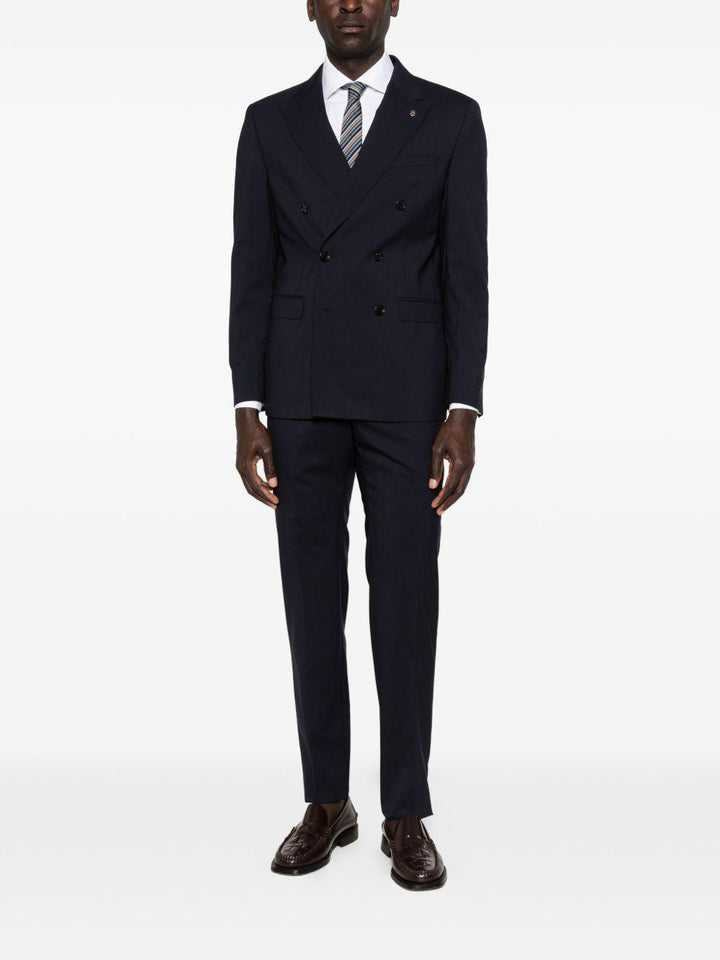 Abito blu navy doppiopetto con spilla sul revers 