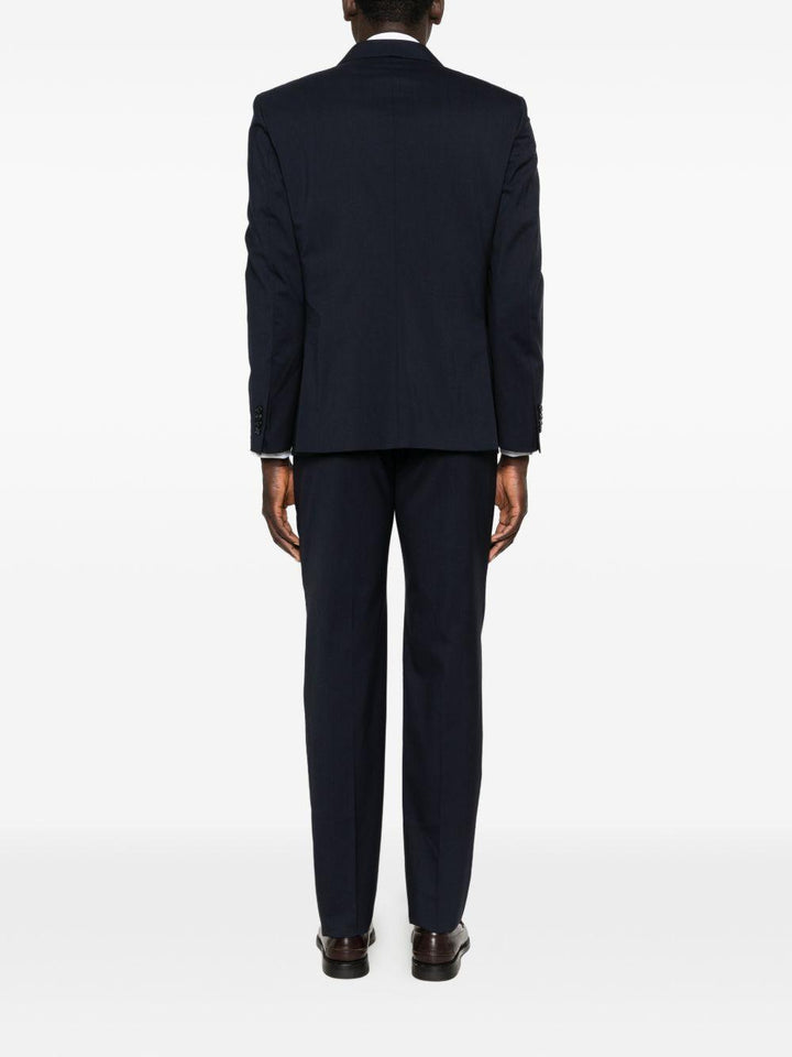 Abito blu navy doppiopetto con spilla sul revers 