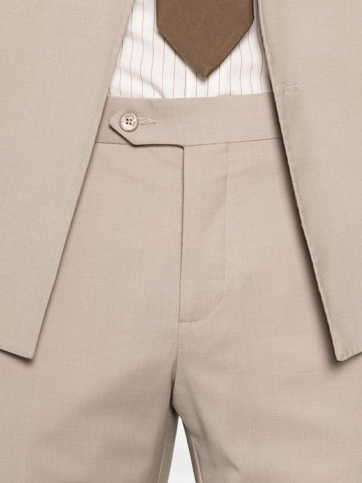 Abito beige doppiopetto con spilla sul revers 