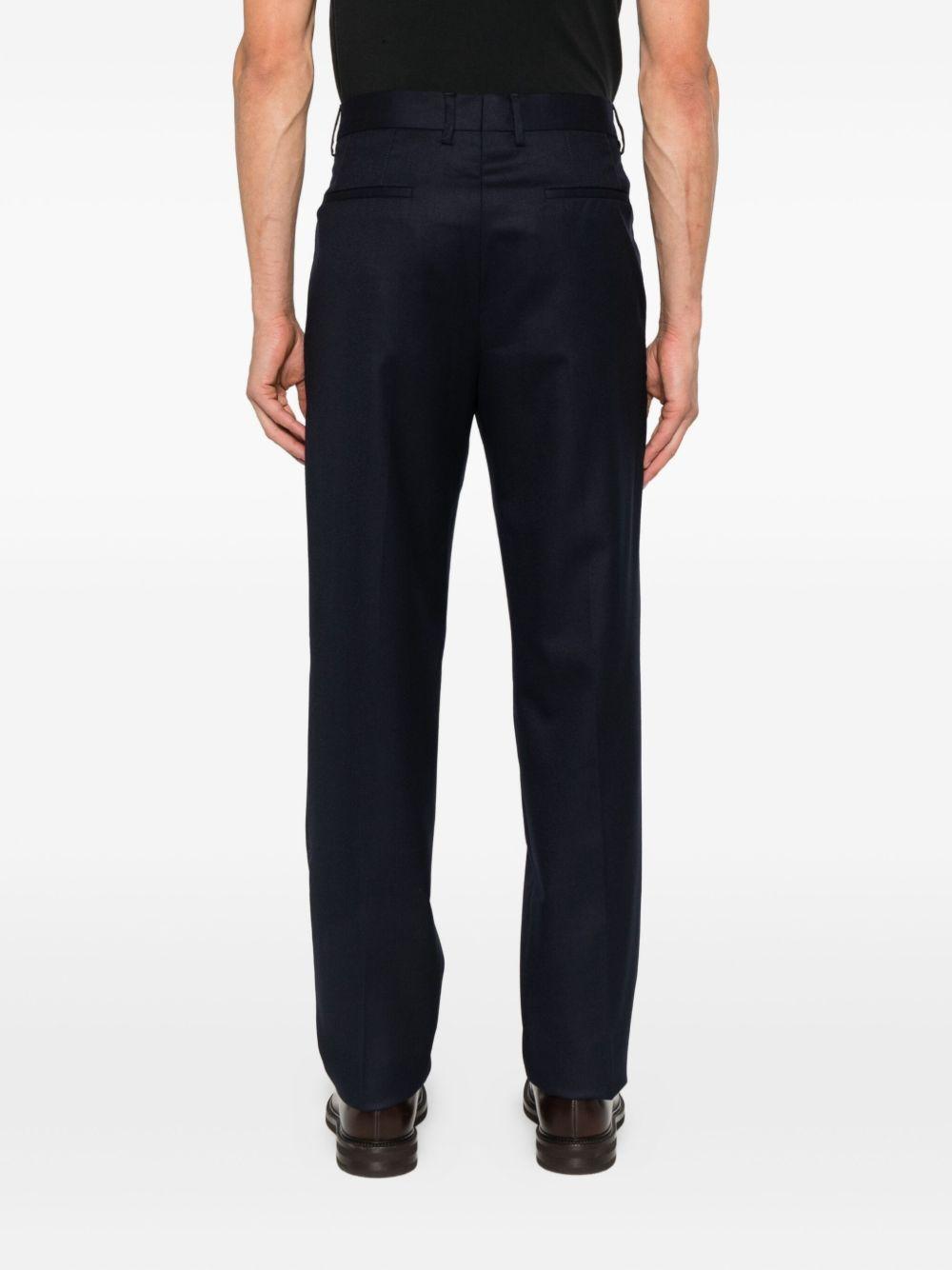 Pantaloni blu scuro in lana plissettati con patta e tasche a filetto 