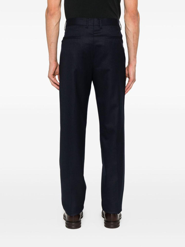 Pantaloni blu scuro in lana plissettati con patta e tasche a filetto 