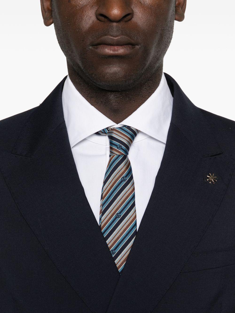 Abito blu navy doppiopetto con spilla sul revers 