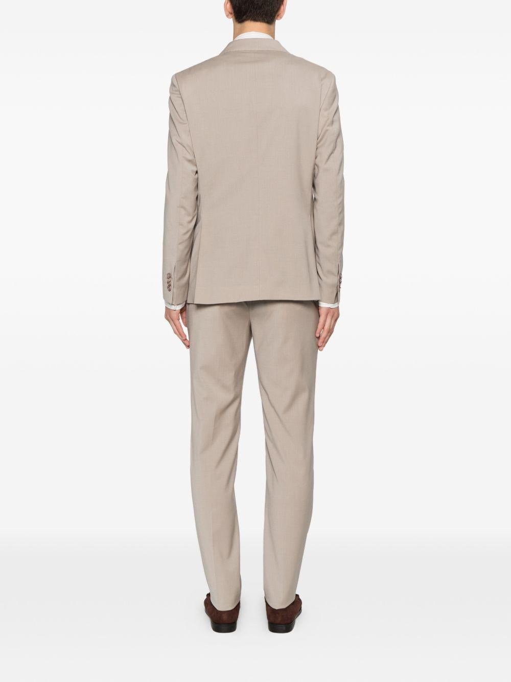 Abito beige doppiopetto con spilla sul revers 
