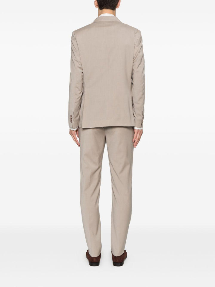 Abito beige doppiopetto con spilla sul revers 