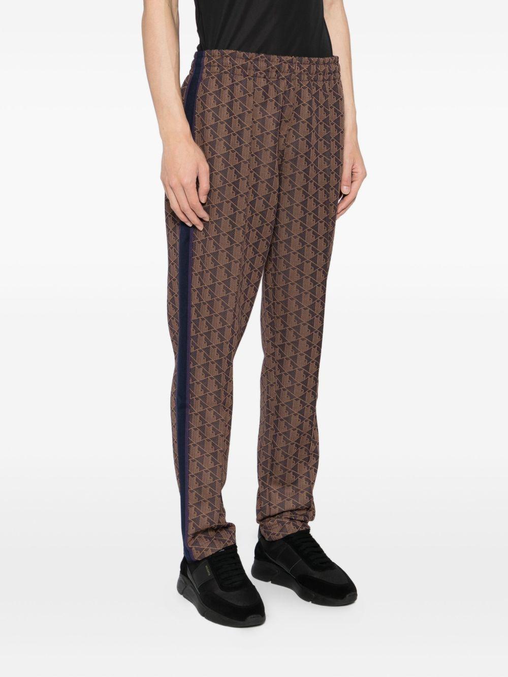 Pantaloni marrone scuro con applicazione logo 