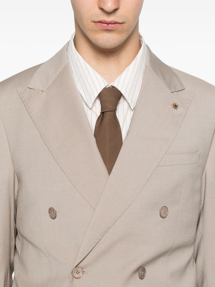 Abito beige doppiopetto con spilla sul revers 