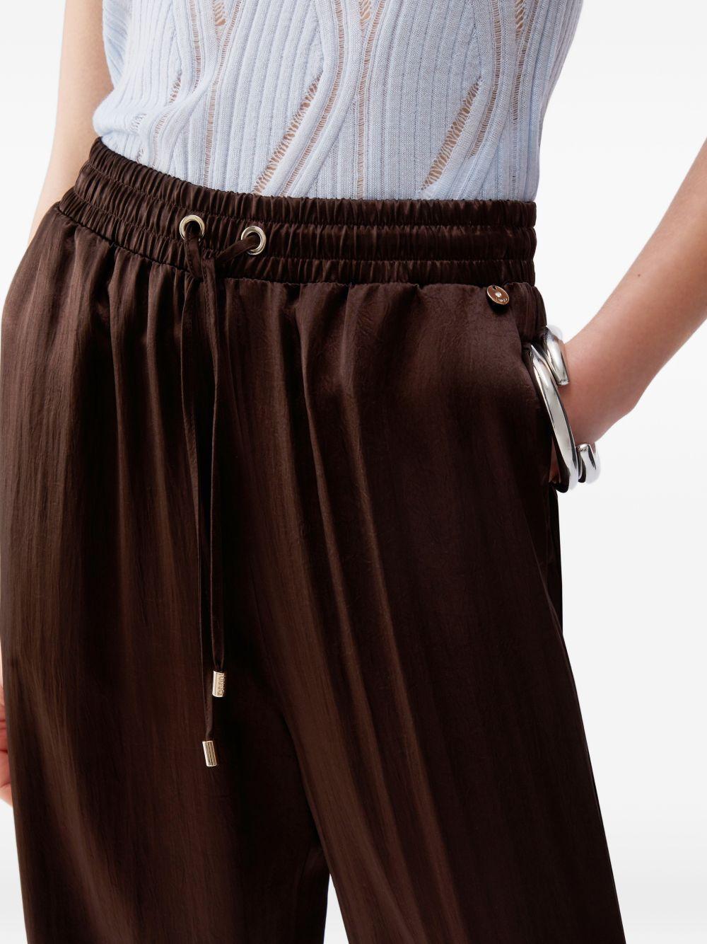 Pantaloni svasati con placca logo 