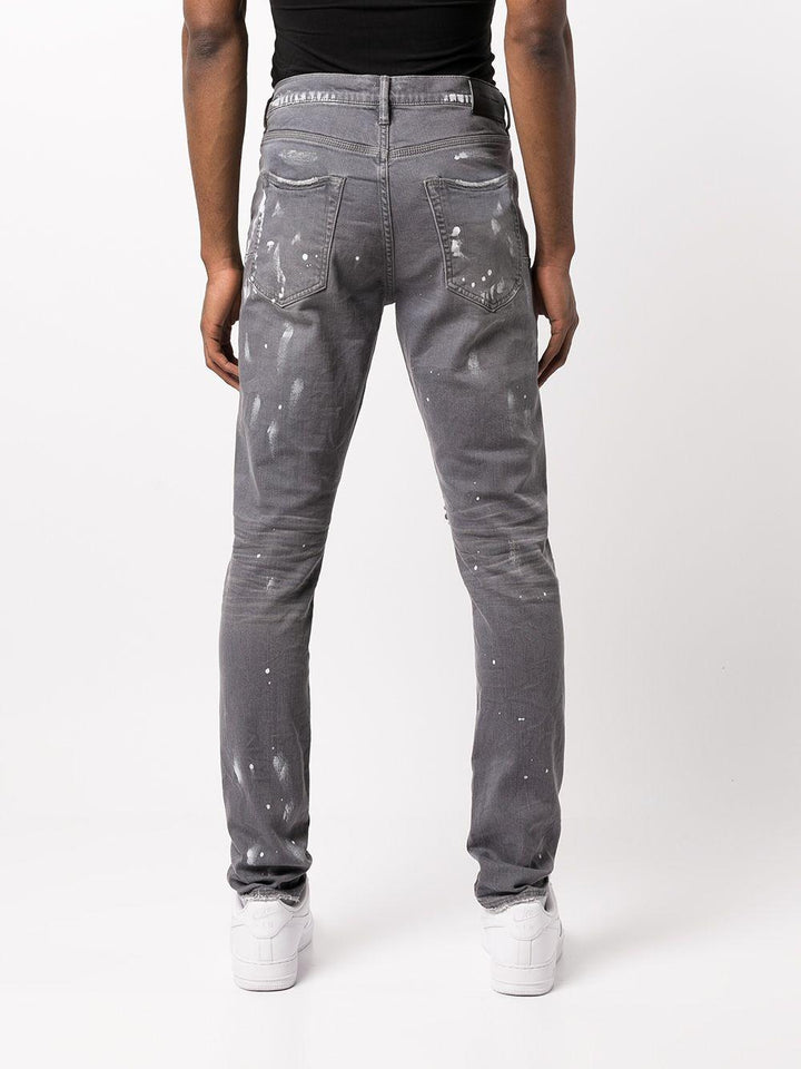 Jeans slim con effetto vissuto e dettaglio vernice 
